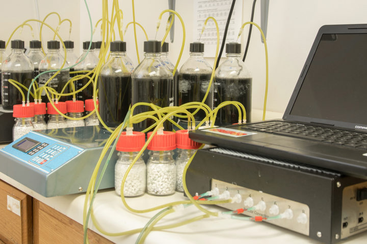 Testing equipment for wastewater treatment plant processes with a laptop, scales, and multiple beakers and tubes