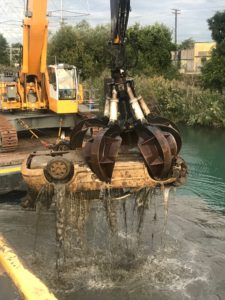Grapple lifts a car during environmental dredging operations.