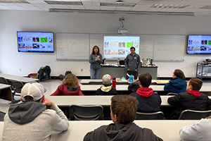 Students watching Sarah Babcock and Nate Jones discussing STEM topics in a classroom.