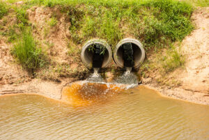 Photograph of two stormwater outlets with water flowing into a channel