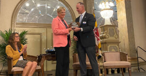 Melissa Smith accepting the National Small Business Service Award from SAME Executive Director Michael Weir.