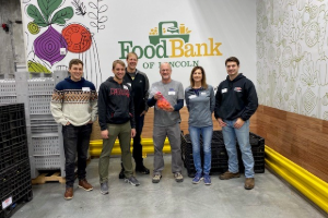 Six EA employees standing in front of a Lincoln food bank sign