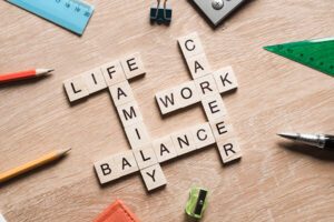 Wood squares with letters on them spell out life, family, balance, career, and work on a desktop