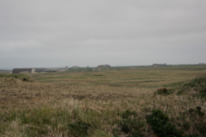 Grass field with a U.S. Air Force base support center in the background