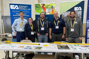 EA's Warwick team gathered infront of a EA booth at a STEM event.