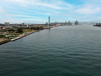 Oblique aerial of the Detroit River with the Ambassador Bridge in the background.