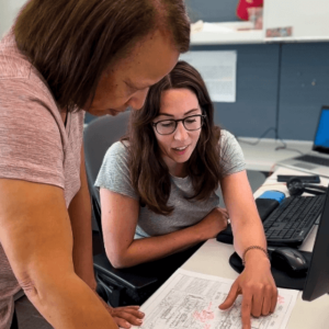 Two EA employees review a drawing at a desk