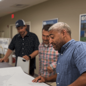 EA employees meeting at a table looking at engineering drawings