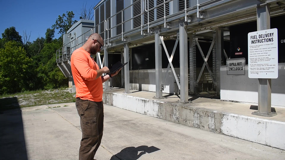 EA employee uses a tablet to completes a compliance inspection at an above ground storage tank at a Howard County facility.