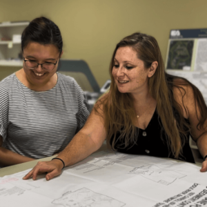 Smiling EA employees working on a drawing