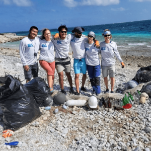 EA employees pose arm in arm following a trash collection event on Johnston Atoll