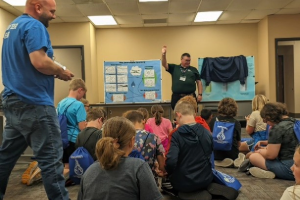 Image of EA volunteers teaching a group of children.