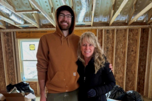 Image of two EA employees in the house they helped build for habitat for humanity.