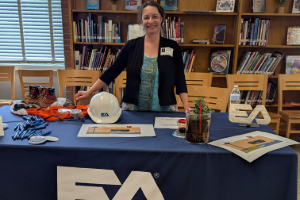 Image of EA employee at EA table set up at the Loch Raven Technical Academy Career Day Fair.