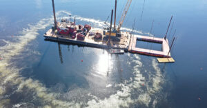 Dredging unit in Torch Lake surrounded by a bubbles created by a bubble curtain