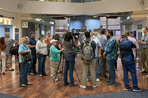 Group of people standing at a civic engagement meeting for a beach management plan
